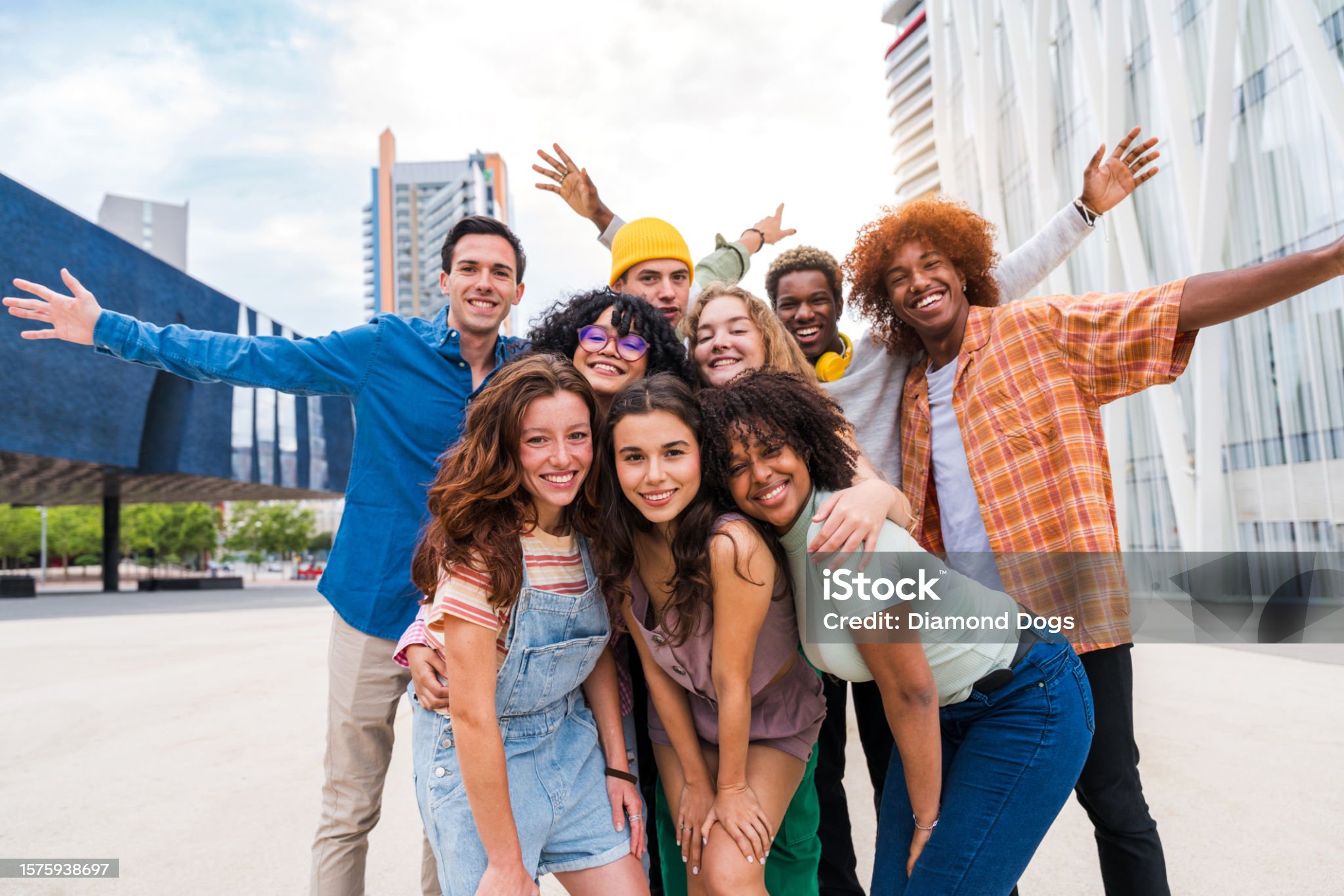 Happy playful multiethnic group of young friends bonding outdoors - Multiracial millennials students meeting in the city, concepts of youth, people lifestyle, diversity, teenage and urban life